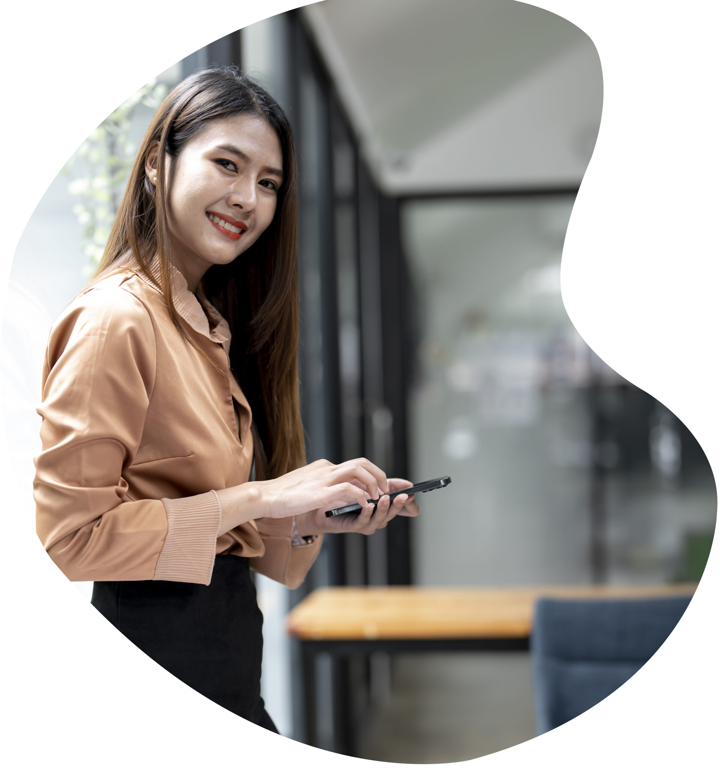 young-businesswoman-hold-with-mobile-phone-standing-office-smiling-looking-camera